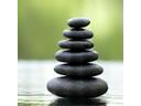 Zen stones balancing on a calm surface, symbolizing meditation benefits.